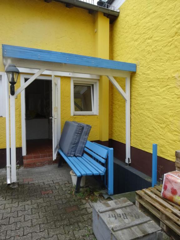 een blauwe bank buiten een geel gebouw bij gelbeshaus1 in Schwalbach am Taunus