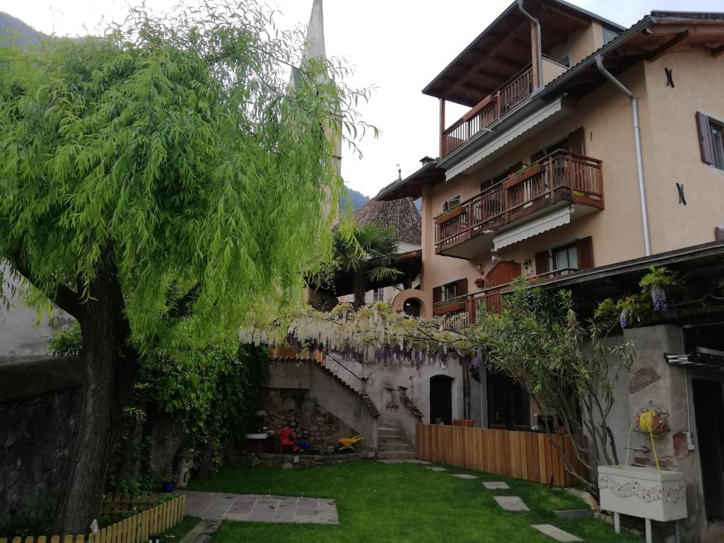 an apartment building with a yard and a tree at Haus Möltner - Apartment Aviam in Caldaro