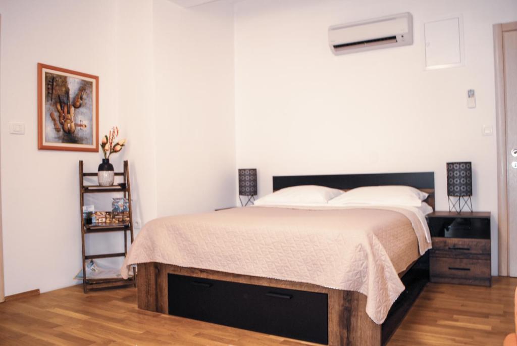 a bedroom with a large bed with a wooden floor at Royal Deluxe in Split