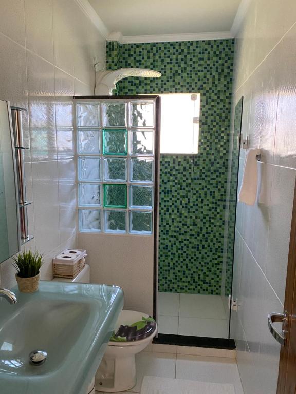 ein Badezimmer mit Waschbecken, Toilette und Dusche in der Unterkunft Casa Rasa in Búzios