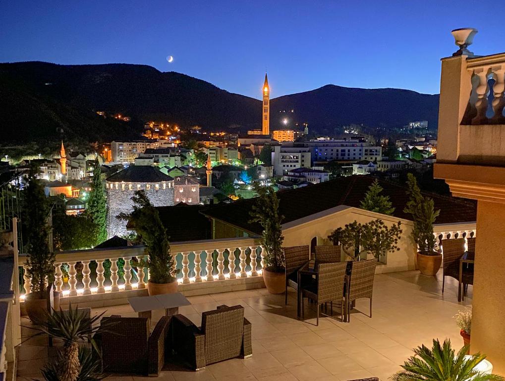 a view of a city from a balcony at night at Shangri La Mansion in Mostar