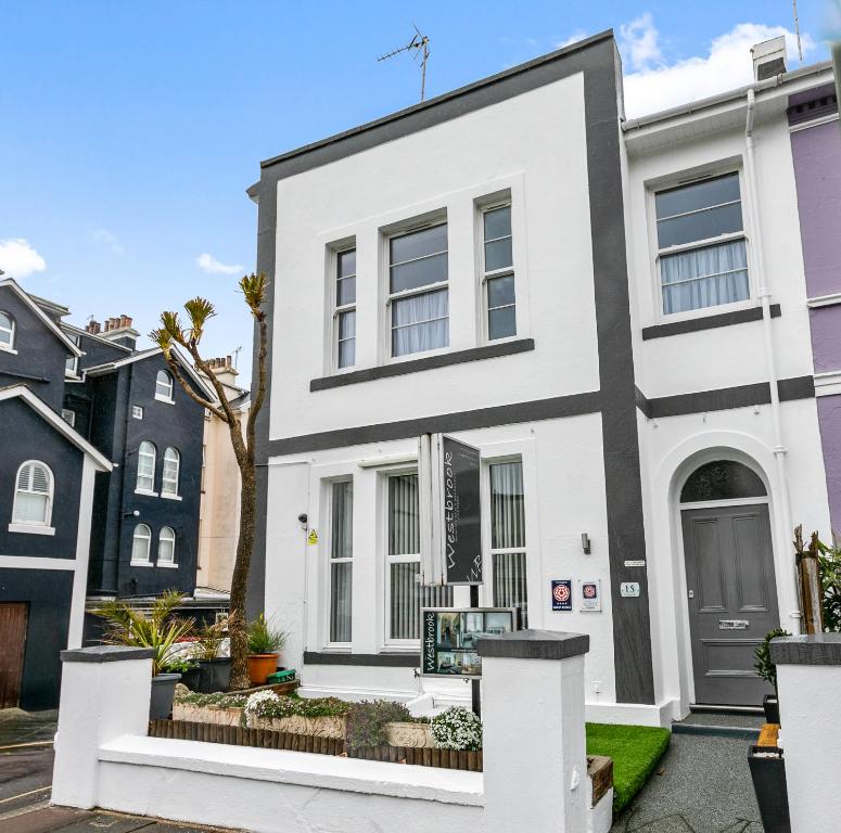 a white house with a black and white facade at Westbrook Guesthouse in Torquay