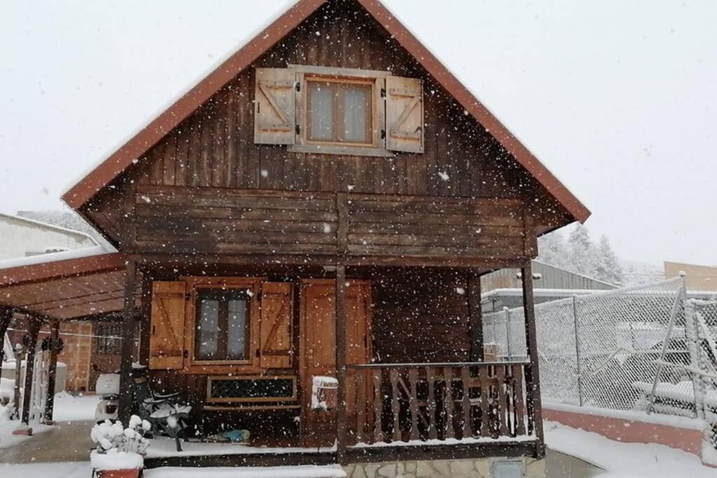 domek z bali w śniegu z opadającym śniegiem w obiekcie Cabaña de madera especial y acogedora w mieście Cardenete