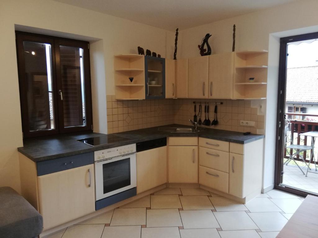 małą kuchnię z białymi szafkami i oknem w obiekcie Haus Möltner - Apartment Aviam w mieście Caldaro