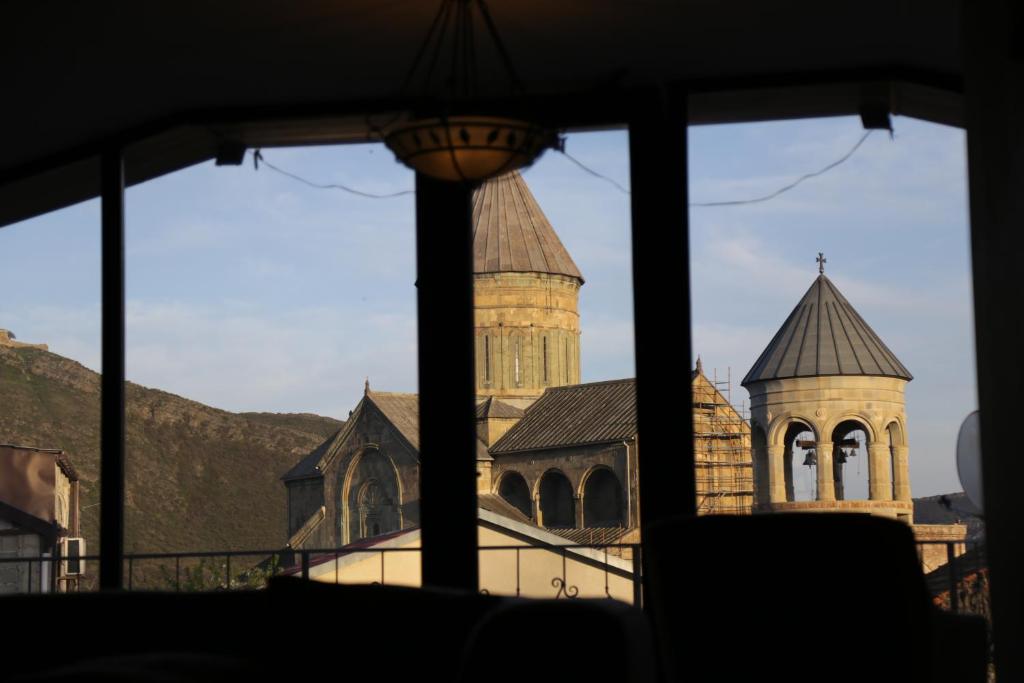 - une vue sur une église à travers une fenêtre dans l'établissement Hotel 12 Tve, à Mtskheta