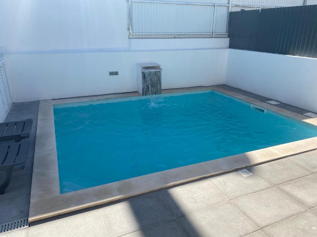 uma grande piscina com água azul num quarto em Summer holiday em Fernao Ferro