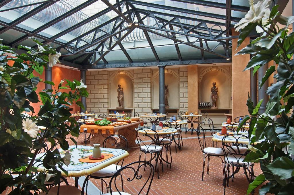 eine Terrasse mit Tischen und Stühlen in einem Gebäude in der Unterkunft Hotel Alba Palace in Florenz