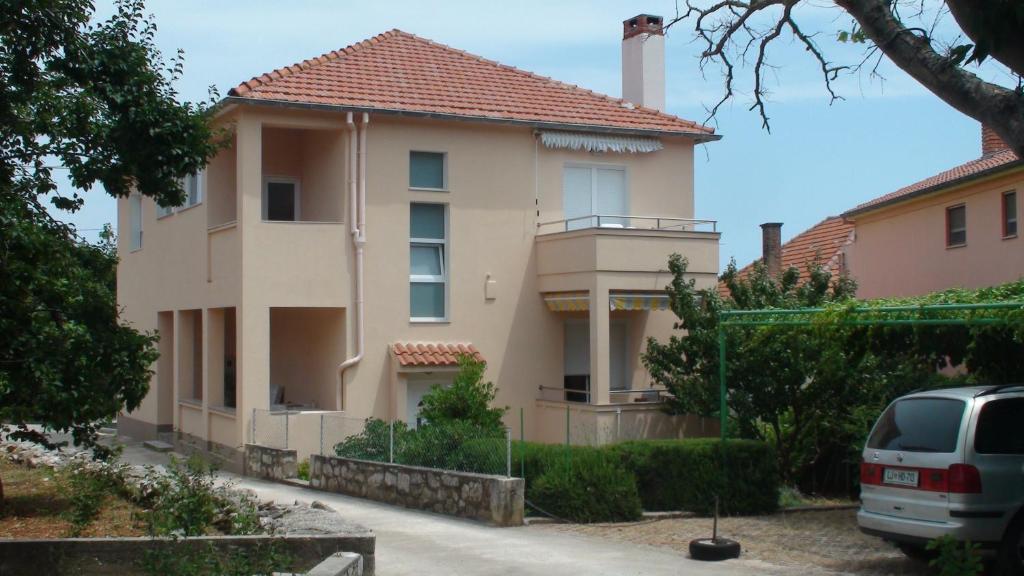 a house with a car parked in front of it at Apartment Davorka in Božava