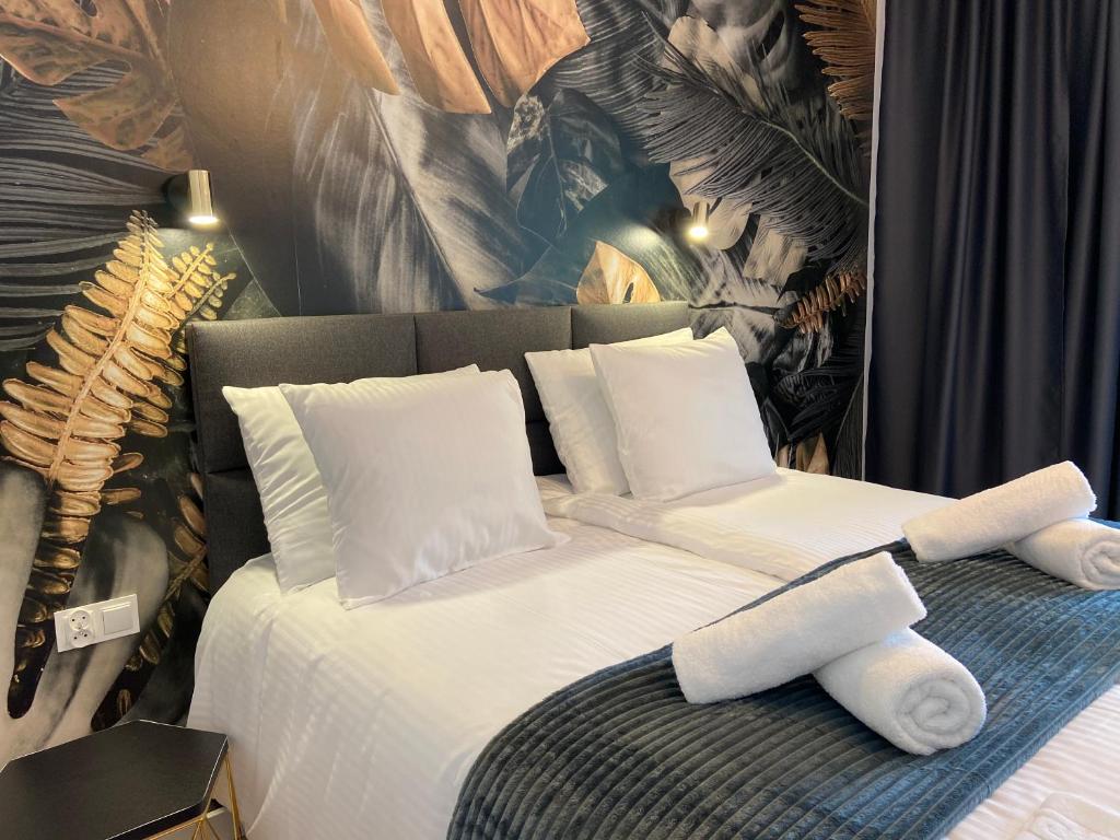 uma cama com lençóis brancos e almofadas em Pokoje gościnne Batial em Jastarnia