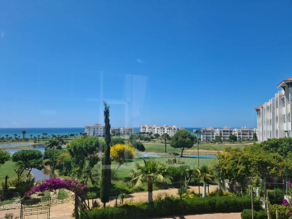 a view of a park with trees and buildings at Asilah Marina Golf Appart in Asilah