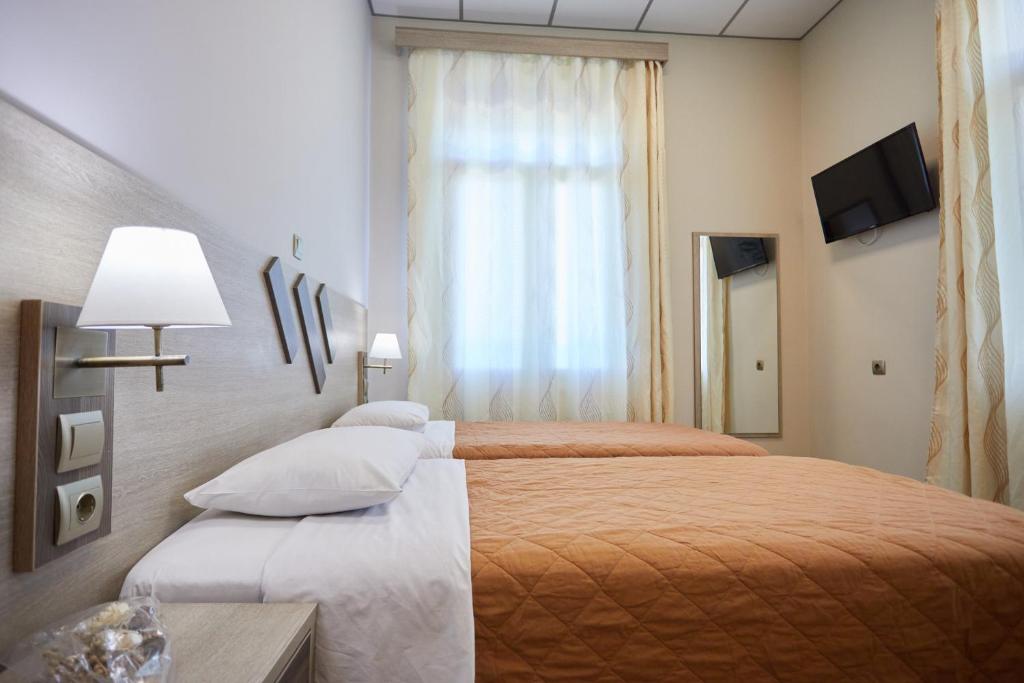 a hotel room with two beds and a window at Amalia City Rooms in Chios
