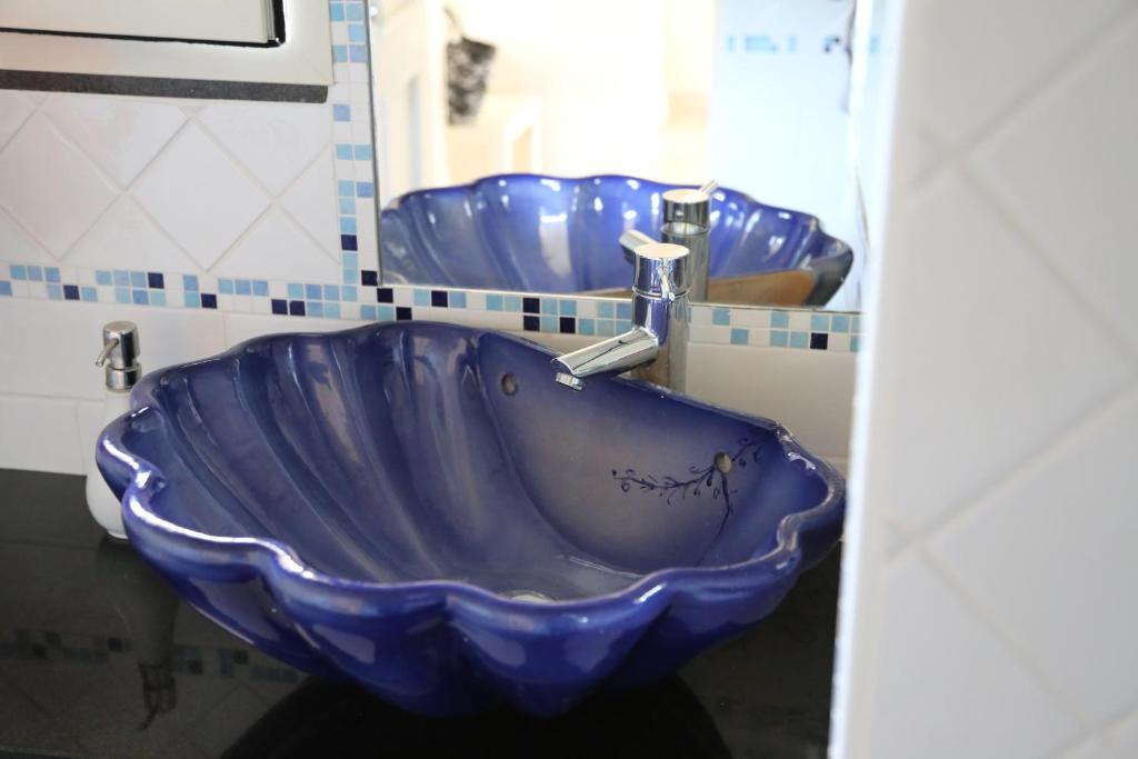 a blue bowl sink in a bathroom with two sinks at Hotel Scilla in Scilla