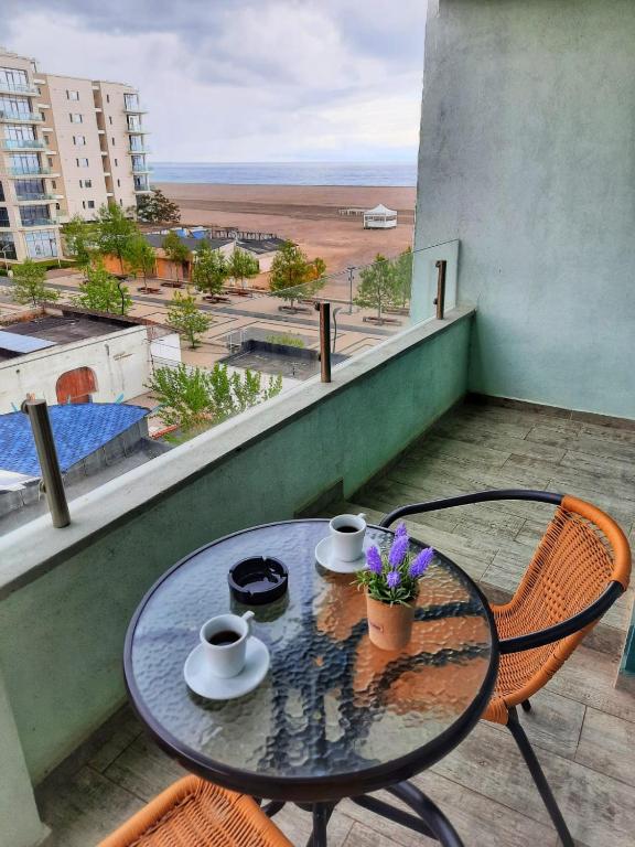 a table and chairs on a balcony with a view of the beach at Hotel Riviera in Mamaia