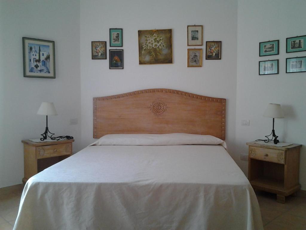 a bedroom with a bed and two nightstands with two lamps at Rubens in Alghero