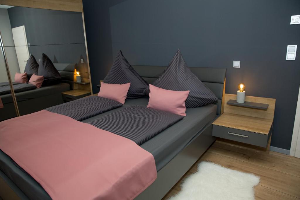 - une chambre avec un lit doté d'oreillers roses et d'un miroir dans l'établissement Schöner Wohnen, à Friesenheim