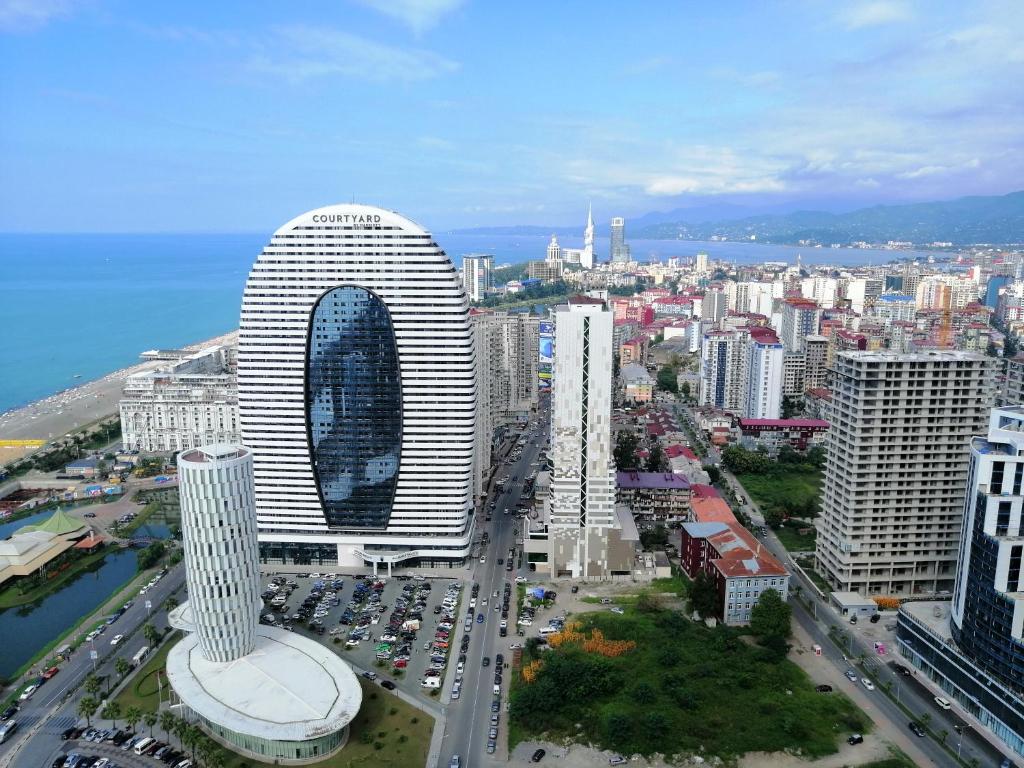 eine Luftansicht auf eine Stadt mit einem großen Gebäude in der Unterkunft Subtropik Apartments in Batumi in Batumi