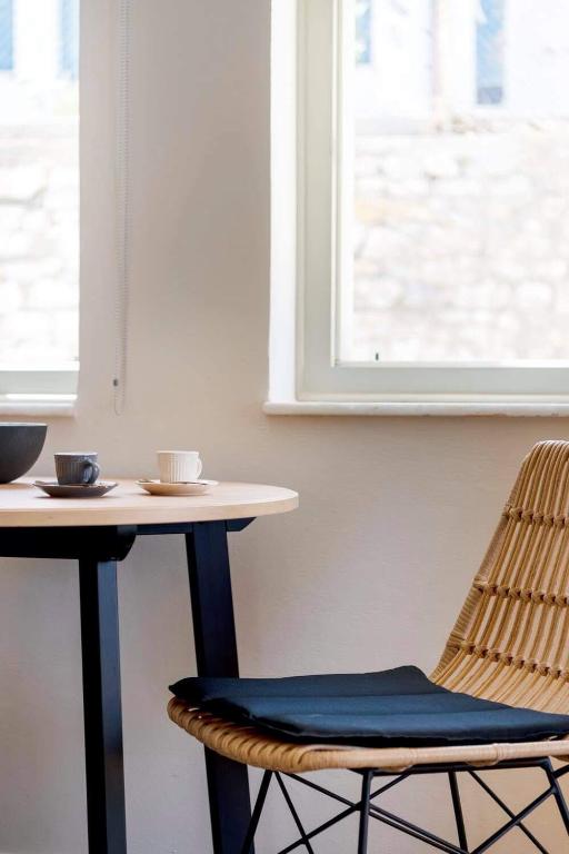 a table with a chair and a table with cups on it at Guesthouse ERI in Kini