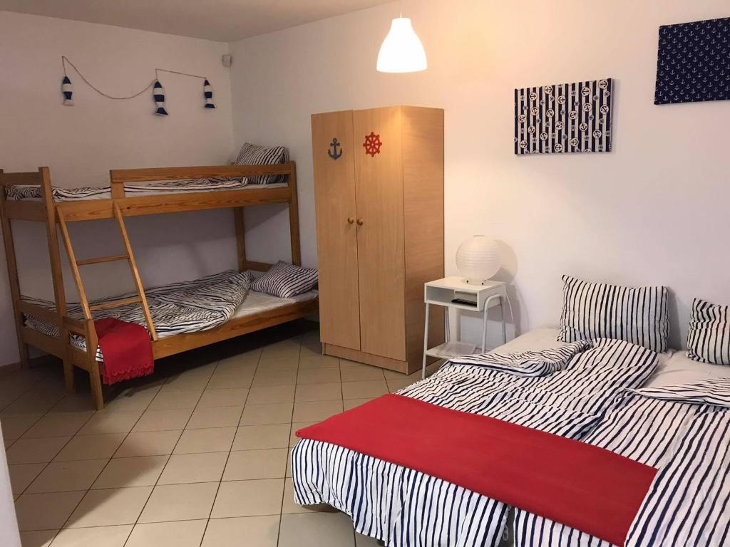 a room with two beds and a bunk bed at Relaks Rusinowo in Rusinowo