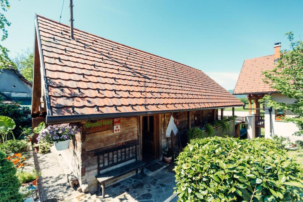 une petite maison avec un toit rouge dans l'établissement Kmečka hiša Bahor, à Črnomelj