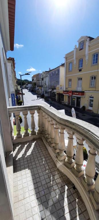 a balcony with a white railing on a city street at CasAzulApartments in Sintra