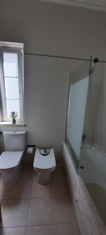 a white bathroom with a toilet and a shower at CasAzulApartments in Sintra