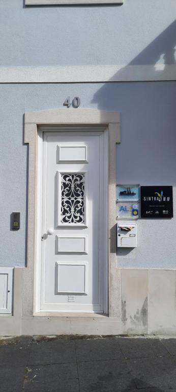 a white door on a building with a sign on it at CasAzulApartments in Sintra