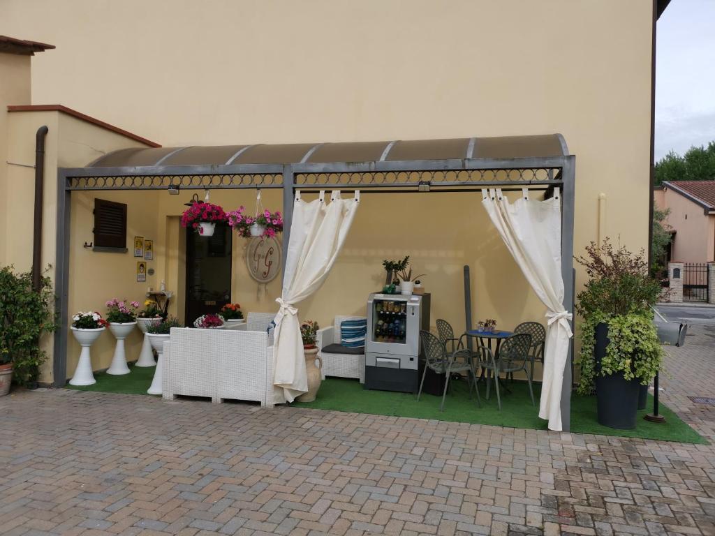 a pavilion with white curtains and a table and chairs at La Locanda Di Giada e Giorgia in Pisa