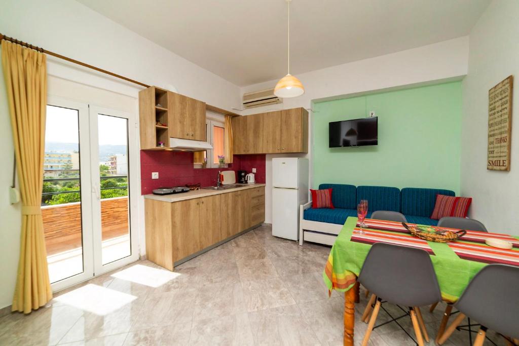 a kitchen and a dining room with a table and chairs at La Stella Apartments in Amoudara Herakliou