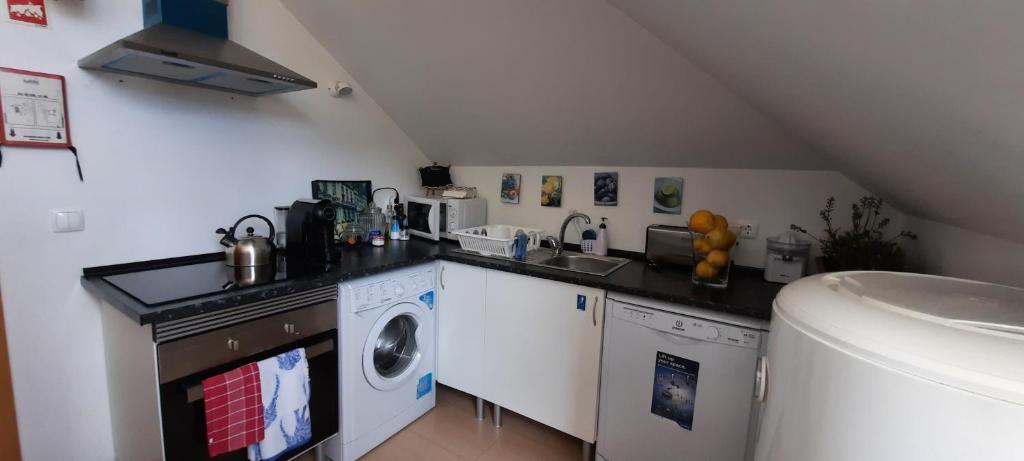a kitchen with a sink and a washing machine at CasAzulApartments in Sintra