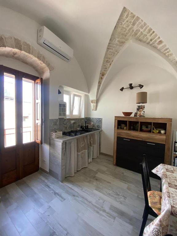 a kitchen with white walls and a wooden door at Un Cuore e Due Capanne in Ceglie Messapica