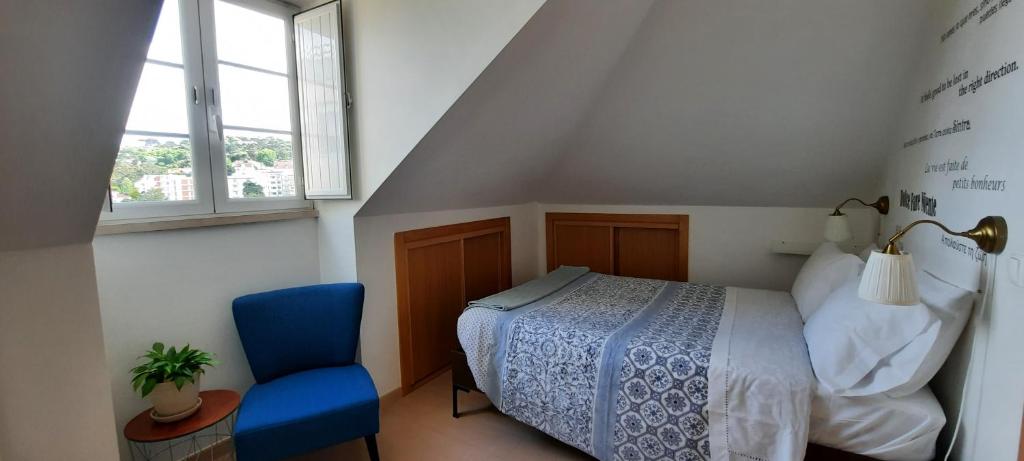 a bedroom with a bed and a blue chair at CasAzulApartments in Sintra