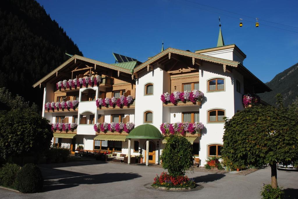 un gran edificio blanco con cajas de flores. en Hotel Garni Ferienhof, en Mayrhofen