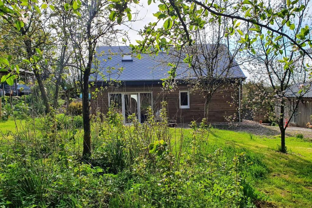 dom w ogrodzie z drzewami i trawą w obiekcie Le chalet des Oisaï w mieście Wibrin