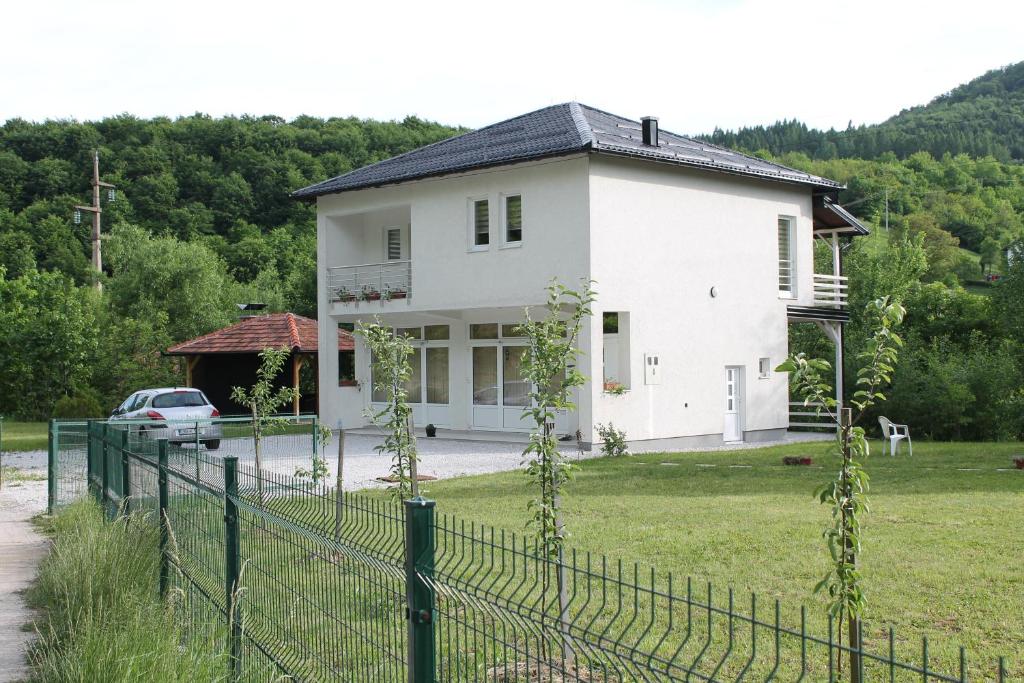 uma casa branca com uma cerca à frente. em Nadia's home em Ilidža