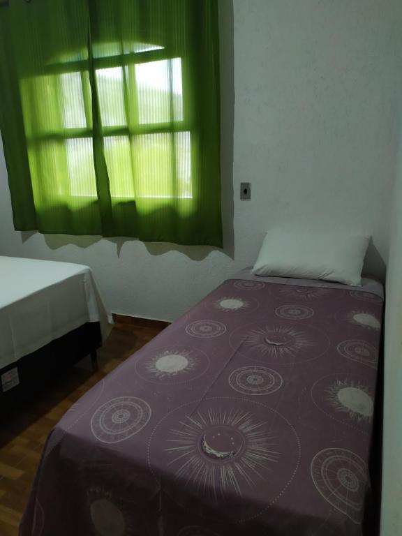 a bedroom with a bed with a purple blanket and a window at Quarto duplo aconchegante com banheiro privativo, ambiente inteiro in Barueri