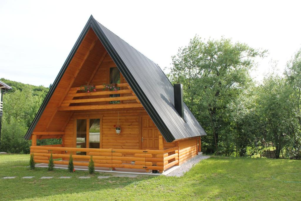 une cabane en rondins avec un toit noir dans l'établissement Nadiaa Wood House, à Ilidža