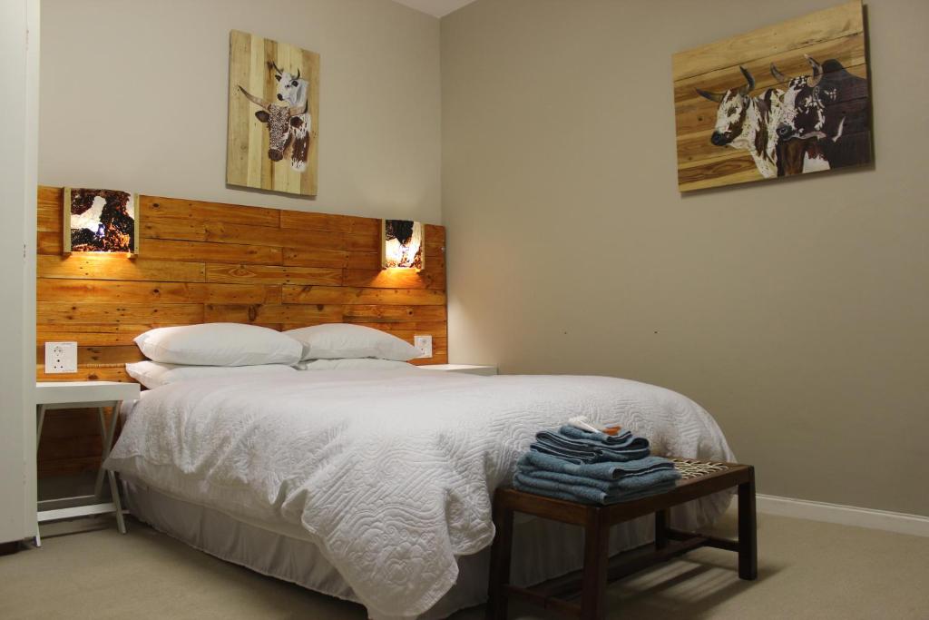 1 dormitorio con cama blanca y cabecero de madera en GlassTree B&B, en Bredasdorp