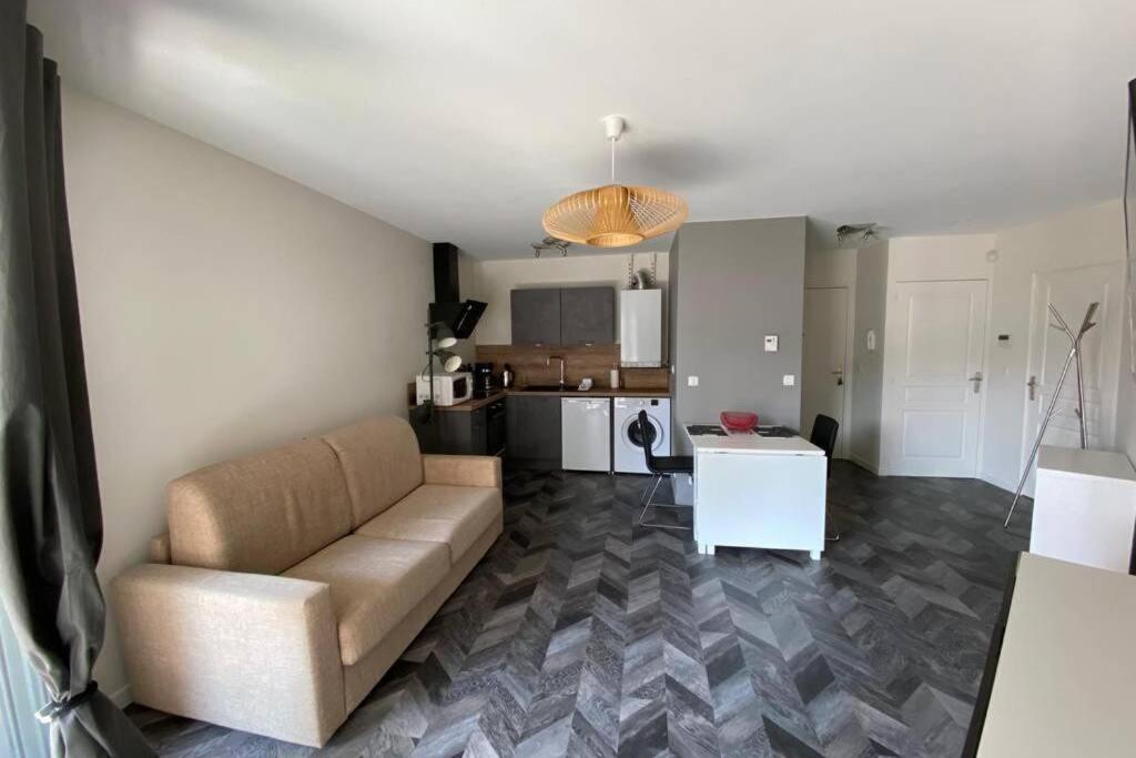 a living room with a couch and a kitchen at Jeremy T2 idéalement situéThonon centre avec terrasse et garage in Thonon-les-Bains