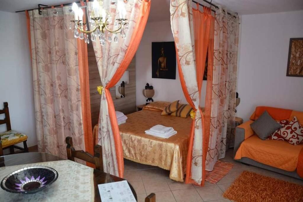 Cette chambre comprend un lit, une table et un canapé. dans l'établissement La Cuppulata - Stile Classico, à Enas
