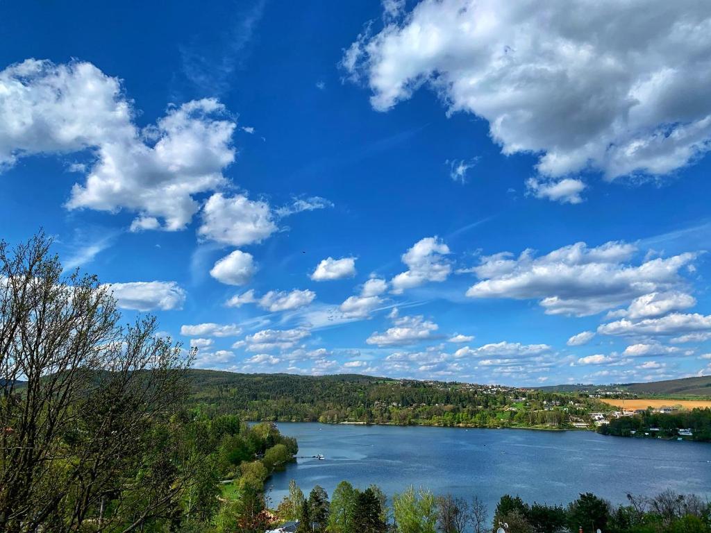 een uitzicht op een rivier met een blauwe lucht en wolken bij Penzion Kozí Horka u Brněnské přehrady in Brno