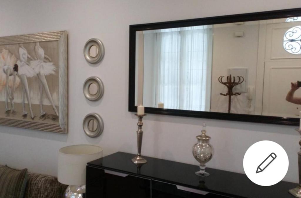 uma sala de estar com um espelho e uma cómoda em Apto Patio Andaluz. Máximo Confort y Limpieza em Cádiz