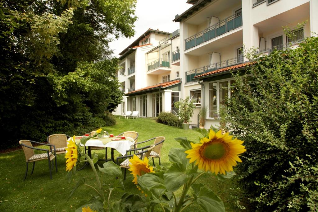 een tafel en stoelen in de tuin van een gebouw bij Apart-Hotel Pension Roßmayer in Bad Füssing