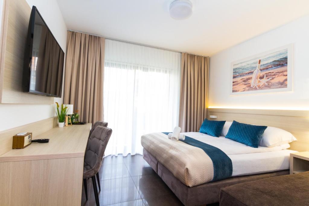 グジボボにあるAkwamarynのベッドとデスクが備わるホテルルームです。