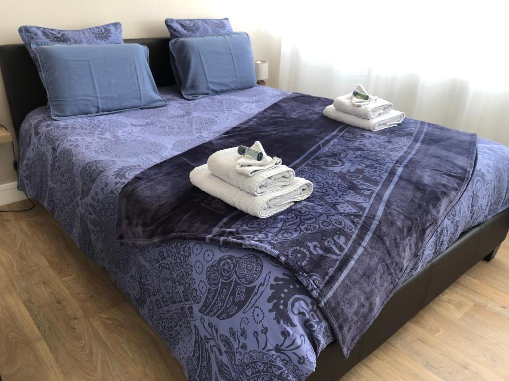 een slaapkamer met een bed met handdoeken erop bij UNE PAUSE SUR LA CÔTE in Boulogne-sur-Mer