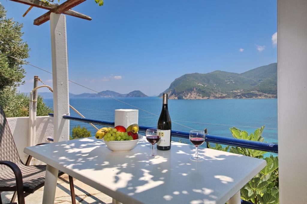 スコペロスにあるΣΕΡΓΙΑΝΙ ΣΚΟΠΕΛΟΥのワイン2杯とフルーツ1杯付きのテーブル