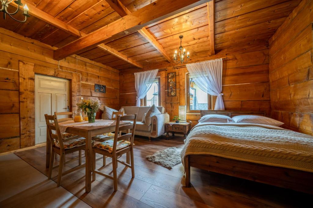 a bedroom with a bed and a table and chairs at Dom Krzesany in Białka Tatrzańska