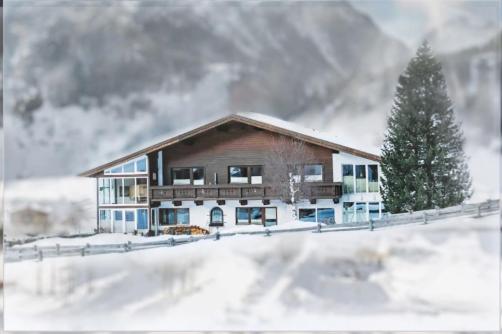 una casa en la nieve con un pino en Haus am Mühlroan, en Sölden