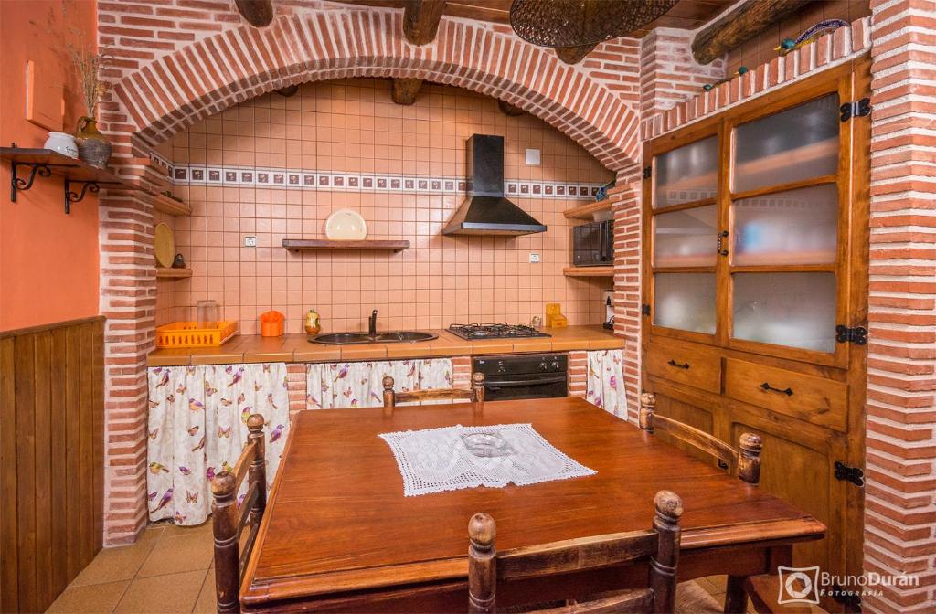 a kitchen with a wooden table in a room at Casa lo Ferre in Beceite