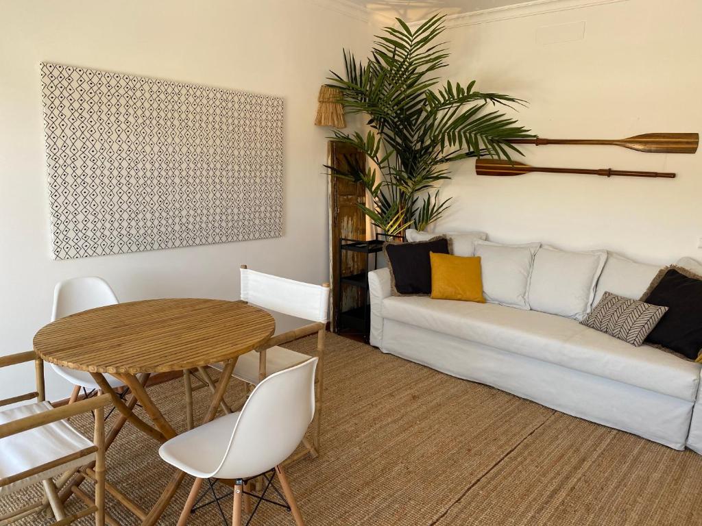 uma sala de estar com uma mesa e um sofá em Casa da Várzea em Odeceixe