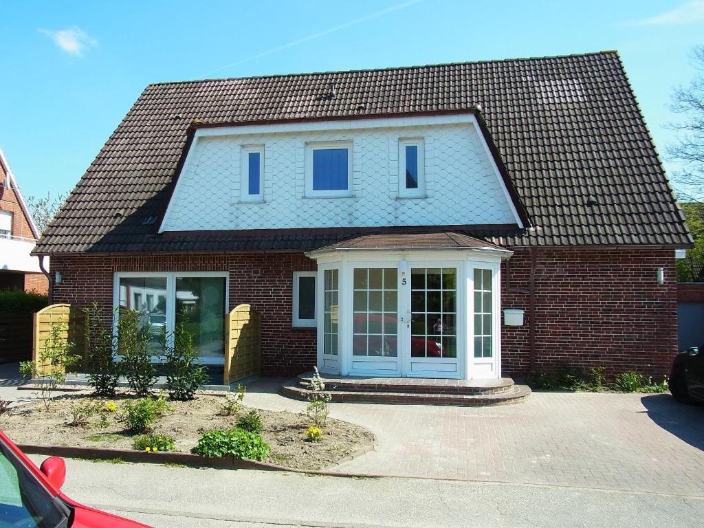 ein rotes Backsteinhaus mit einer weißen Tür in der Unterkunft Haus Köhler in Büsum